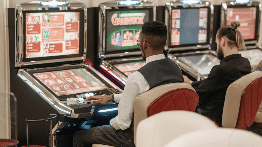 men sitting in front of slot machines