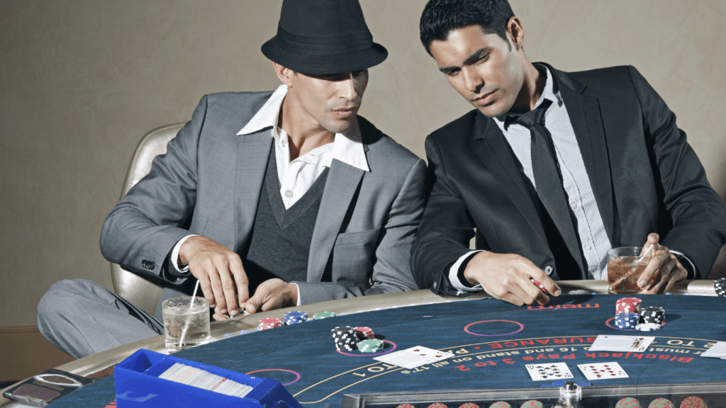 two men talking in front of casino table